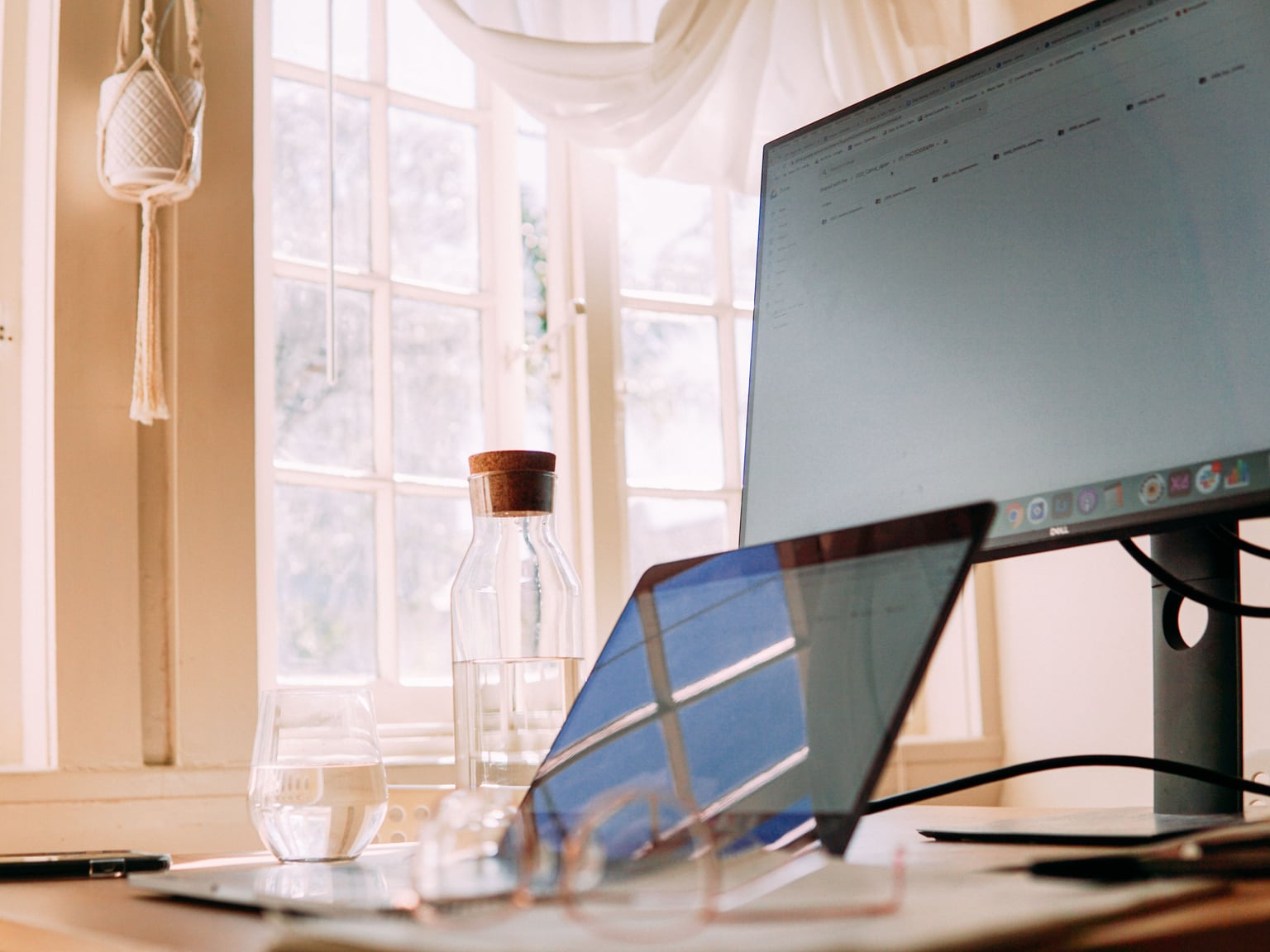 Heller, warmer Arbeitsplatz mit Laptop und Schreibtischlampe